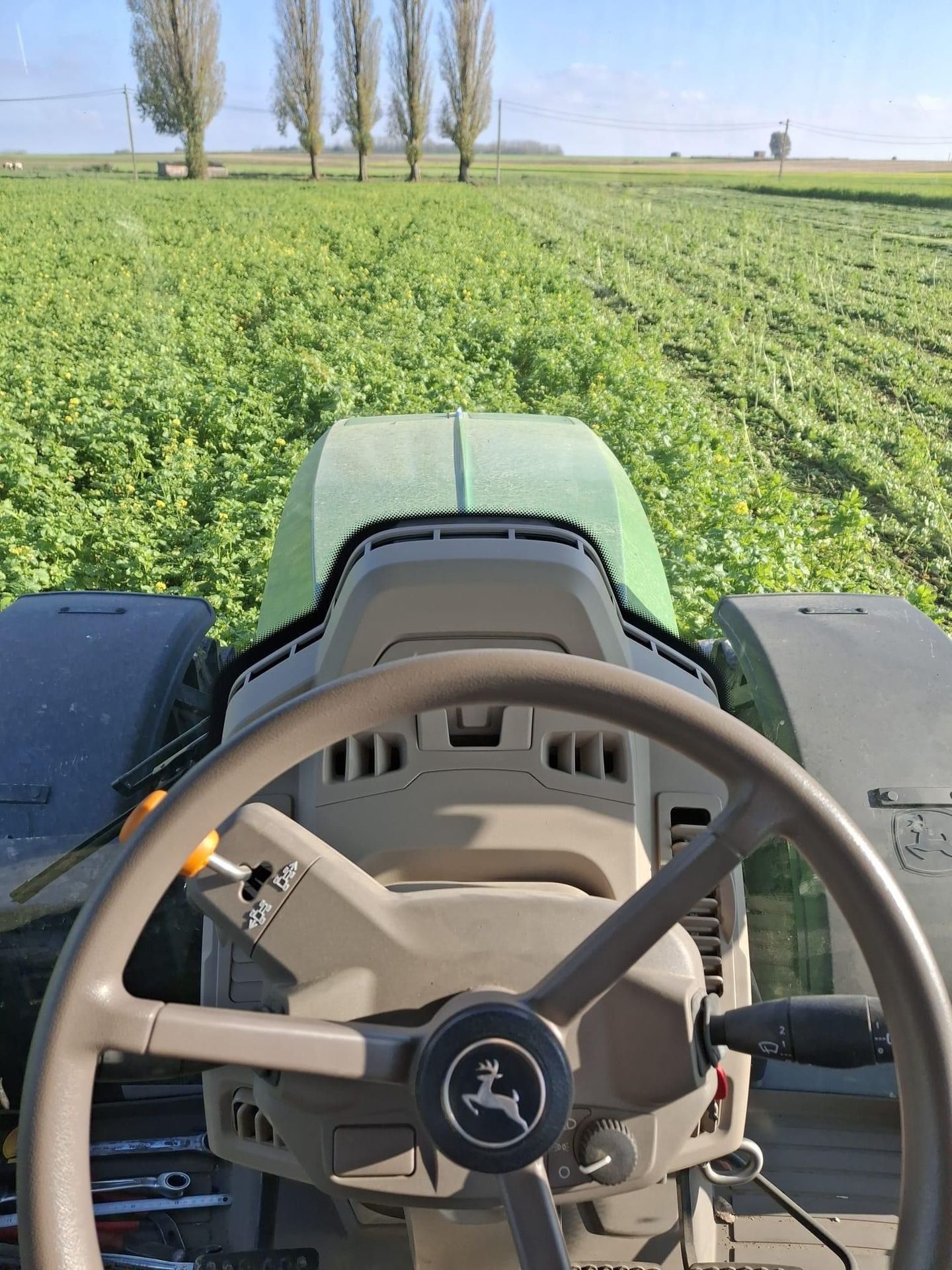 Vue d'un champs vert depuis le siège d'un tracteur